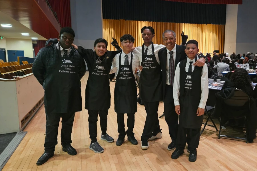 Group of kids wearing black aprons