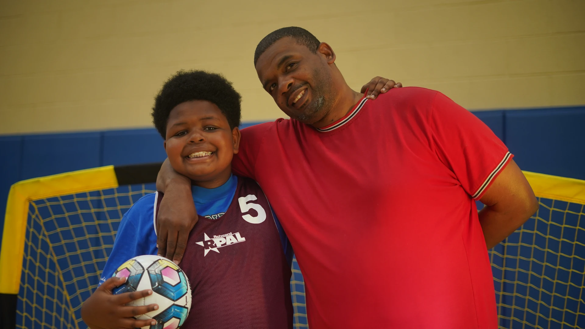 Boy with mentor holding a soccer ball