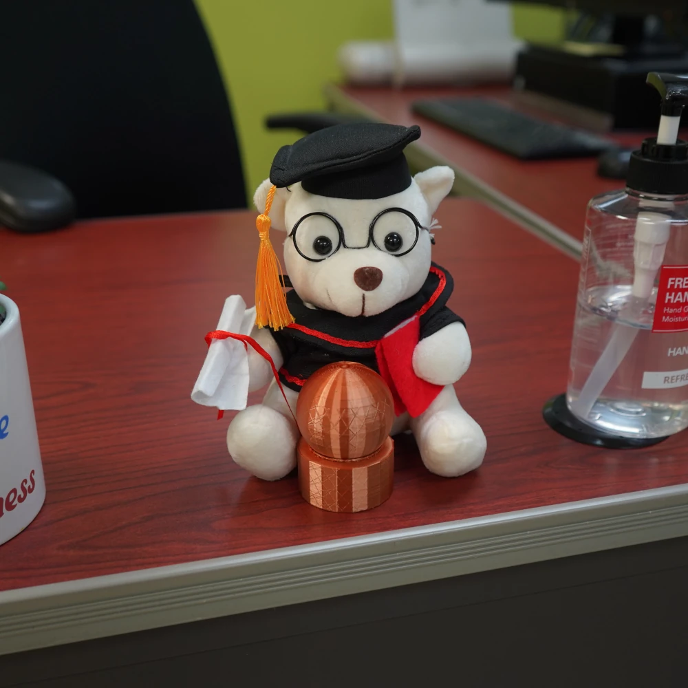 Desktop teddy bear wearing glasses and a graduation cap