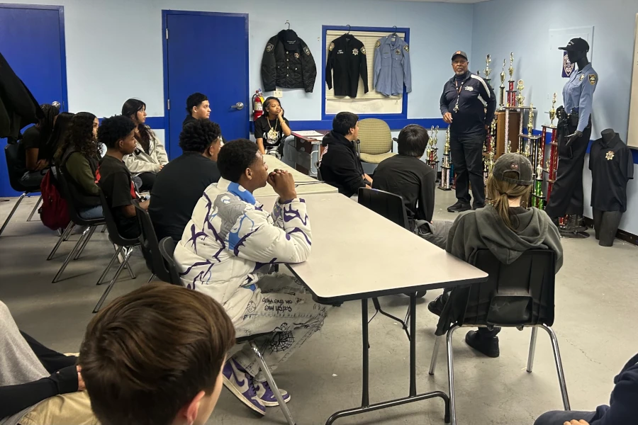 Kids in a classroom with a police officer presenting